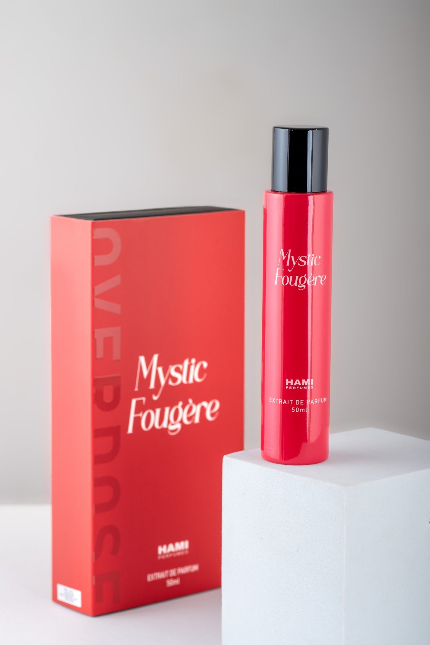 Red perfume bottle and packaging with 'Mystic Fougère' text on a white background